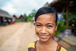 Smiling young girl in a village setting.