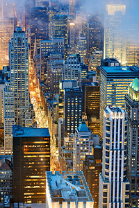 View of Manhattan streets at dusk with city lights shining brigh