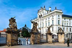 Ornate gates and statues guard a grand European palace.
