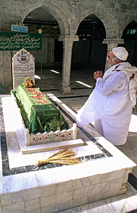 Man praying at a shrine in Pakistan during daylight hours