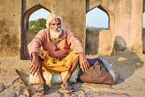 Holy man sitting outside historic building in Orchha India