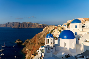 Santorinis iconic blue domes and white buildings overlooking th
