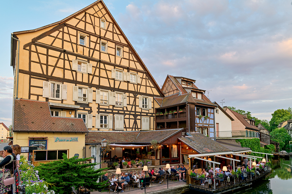 Dining by the canal in Colmar with timber framed houses in view Print