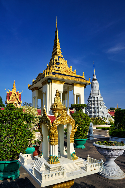 Golden temples and a grey stupa under a clear blue sky. Print