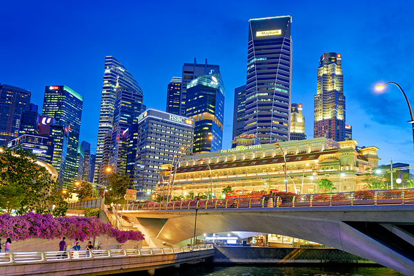 People walk by the waterfront in Marina Bay during sunset in Sin Print