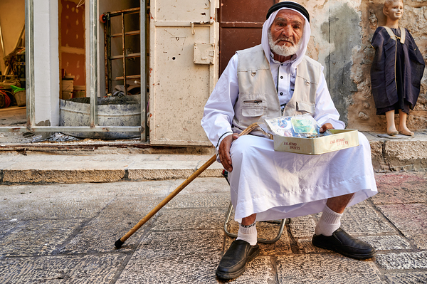 Old man sits in the old city of Jerusalem asking for help Print