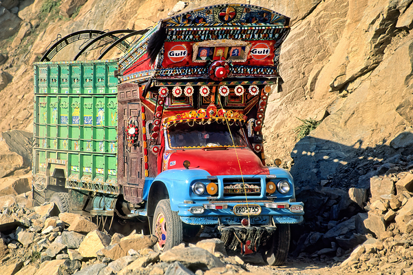 Trucks travel toward Shandur Pass in Pakistans rugged terrain Print