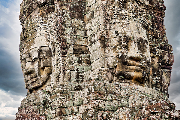 Ancient stone faces carved into Bayon Temple Cambodia. Print