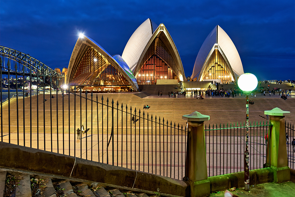 Sydney Opera House illuminated at dusk with crowds on steps. Print