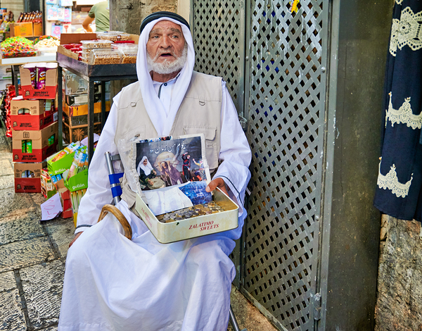 Beggar in the old city of Jerusalem seeks help from passersby Print