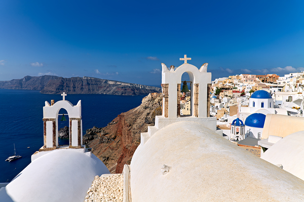 Santorinis iconic white churches blue domes and caldera view. Print