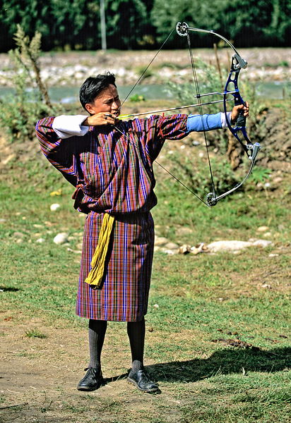 Bhutanese archer in traditional Gho aiming a compound bow. Print