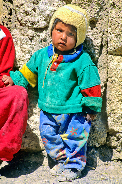 Indigenous child in colorful clothes and yellow hat outdoors. Print