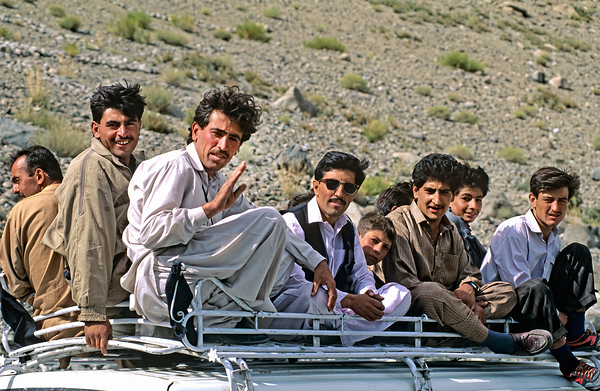 Group traveling on top of a van in Pakistans mountains Print