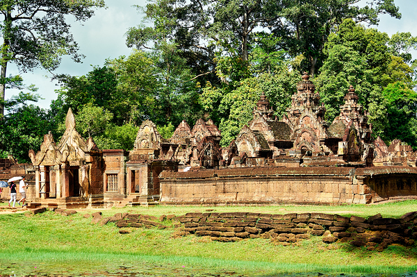 Ancient stone temple complex surrounded by lush jungle and water Print