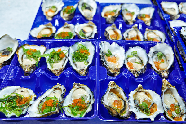Fresh oysters with garnishes in blue trays. Print