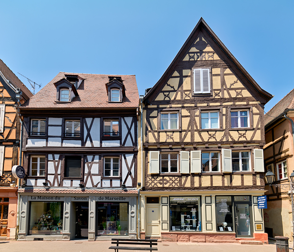 Visitors explore timber framed houses in Colmar Alsace on a sun Print