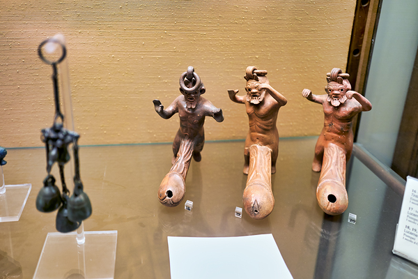 Displays of ancient artifacts are shown in glass cases Print