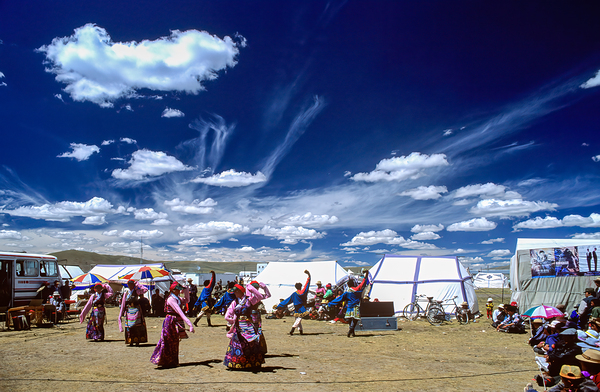 Outdoor festival in Tibet with traditional dancing and tents by Marco Brivio