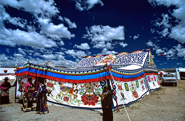 Colorful Tibetan tent with people under a cloudy sky in Tibet Print