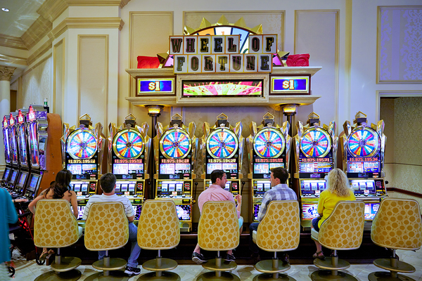 People play slot machines at Venetian Hotel in Las Vegas by Marco Brivio