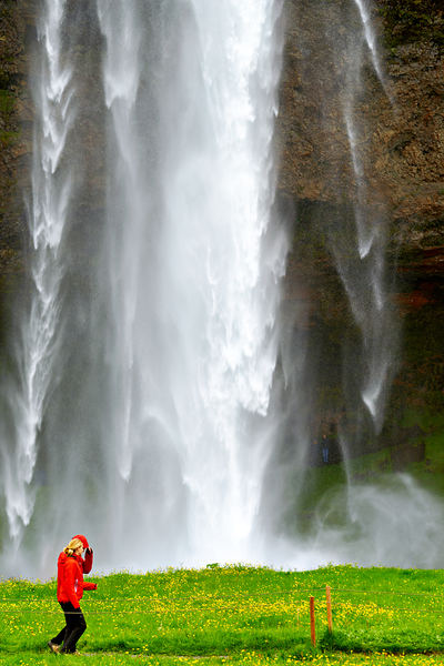 Woman walks near Seljalandsfoss waterfall in Iceland Print
