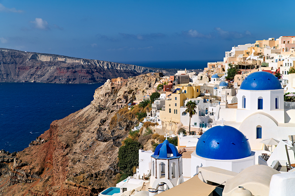Santorinis iconic white buildings and blue domes overlooking th Print
