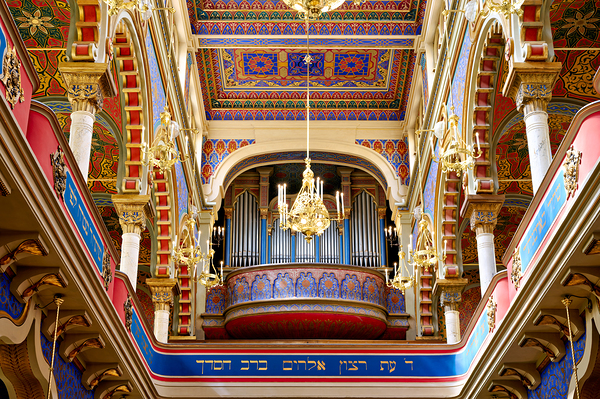 Ornate synagogue interior with organ and chandeliers. by Marco Brivio