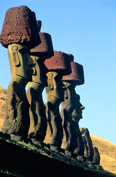 Moai statues with red topknots on Easter Island. by Marco Brivio