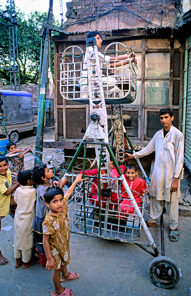 Children enjoy playtime on a swing in Lahore Print
