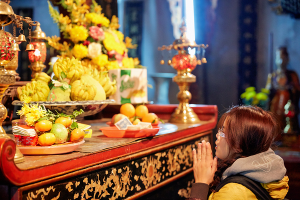 Person offers prayers at altar with fruits in Ho Chi Minh Print