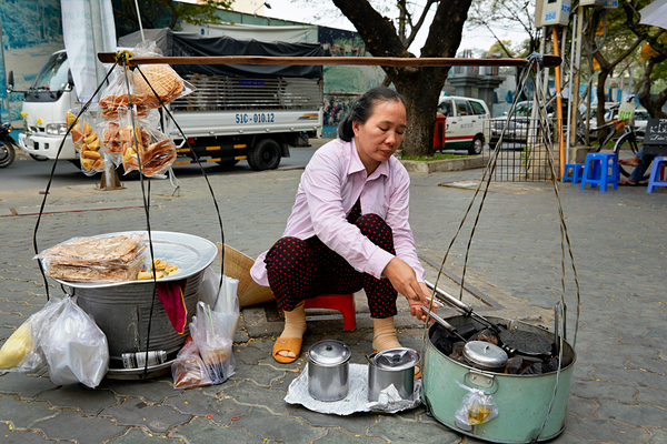 Local vendor preparing street food in Ho Chi Minh City Vietnam by Marco Brivio