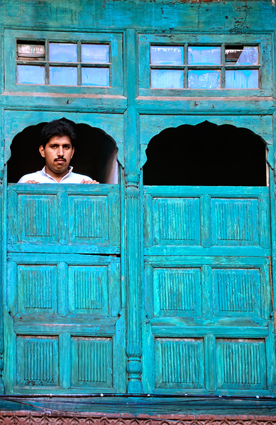 Man looks out from window in Lahore Pakistan Print
