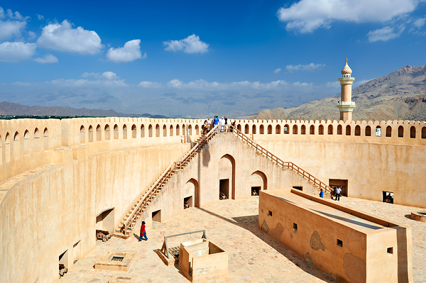 Visit to Nizwa Fort in Oman with visitors and open sky by Marco Brivio