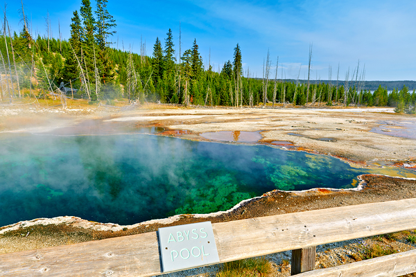 Tourists can see the deep blue Abyss Pool in Yellowstone National Park with steam rising from the hot springs during the warm afternoon. Digital Download