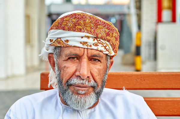Man sitting on a bench in Muscat Oman during the day Print