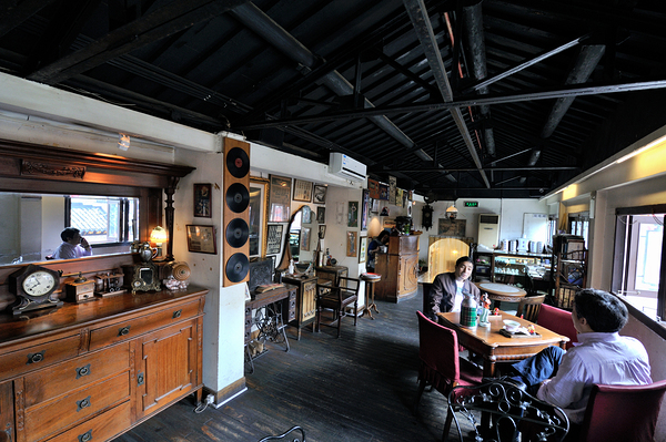 Customers enjoy drinks and food in a vintage cafe in Shanghai Print