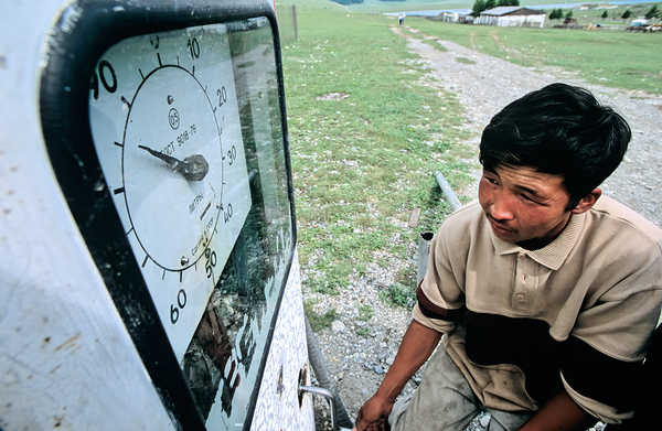 Vintage petrol station in Mongolia with a young man filling up by Marco Brivio