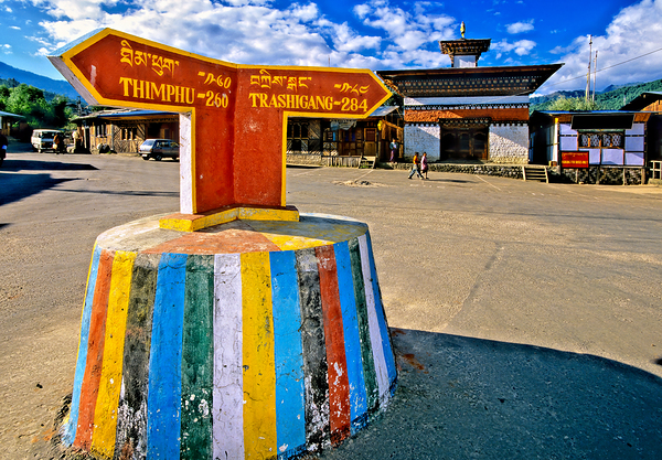 Colorful Bhutanese signpost directs to Thimphu and Trashigang. Print