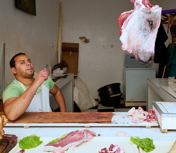 Butcher at work in Meknes souk showing fresh meat and livestock Print