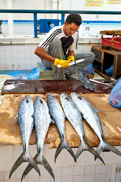 Fish seller prepares catch at Nizwa Oman fish market Print