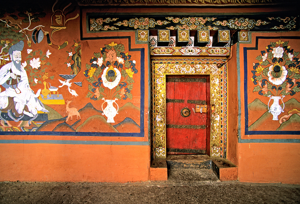 Vibrant wall murals and an ornate red door. by Marco Brivio