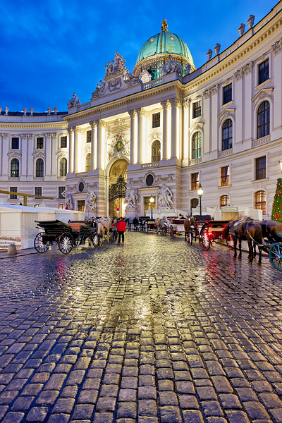 Hofburg Palace Vienna at night with horse drawn carriages. Print