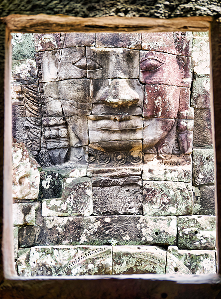 Ancient stone face carving framed in temple window. Print