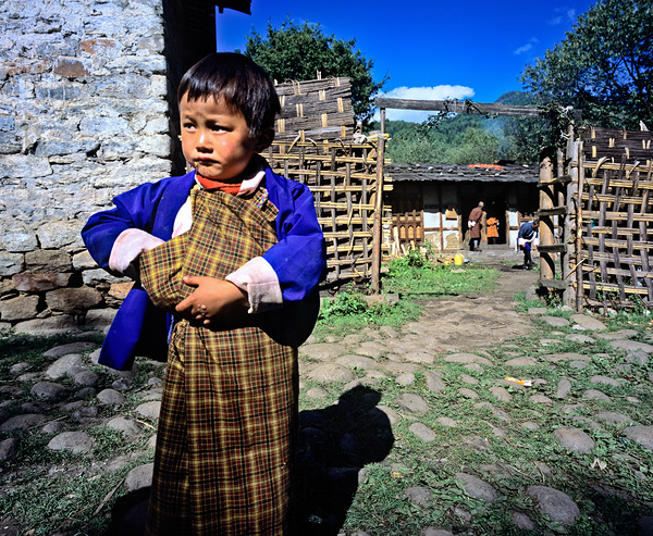 Young child in traditional Bhutanese dress in village. Print