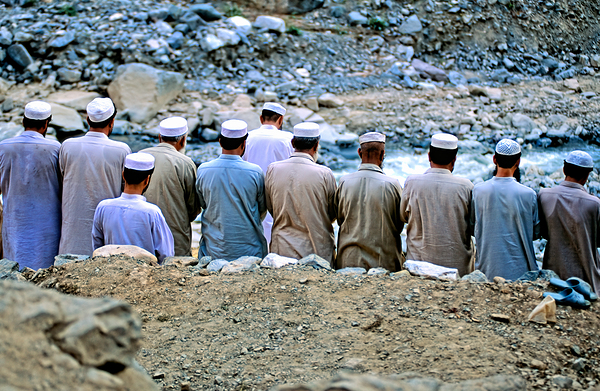 Muslim men pray outdoors in Pakistan facing Mecca by Marco Brivio