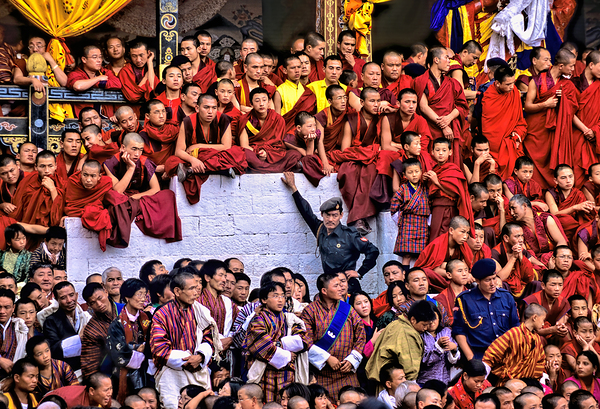 Monks and people observe a traditional Bhutanese ceremony. by Marco Brivio