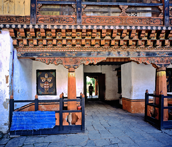 Intricate Bhutanese temple entrance with a person and fierce mas Digital Download