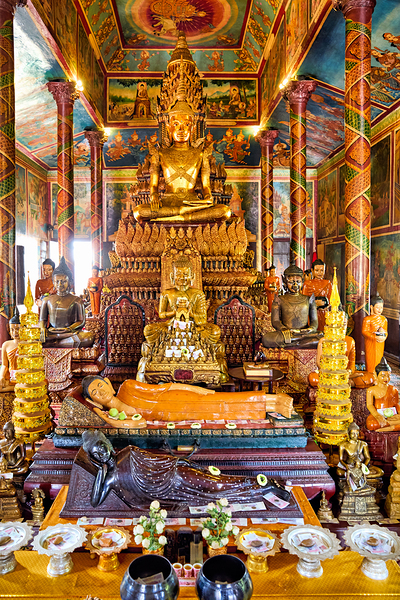 Golden Buddha statues and offerings in an ornate temple. Print