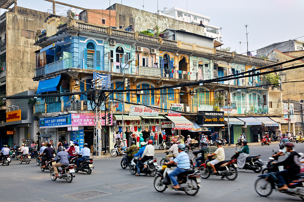 Busy street scene in Ho Chi Minh City with motorbikes and shops Print